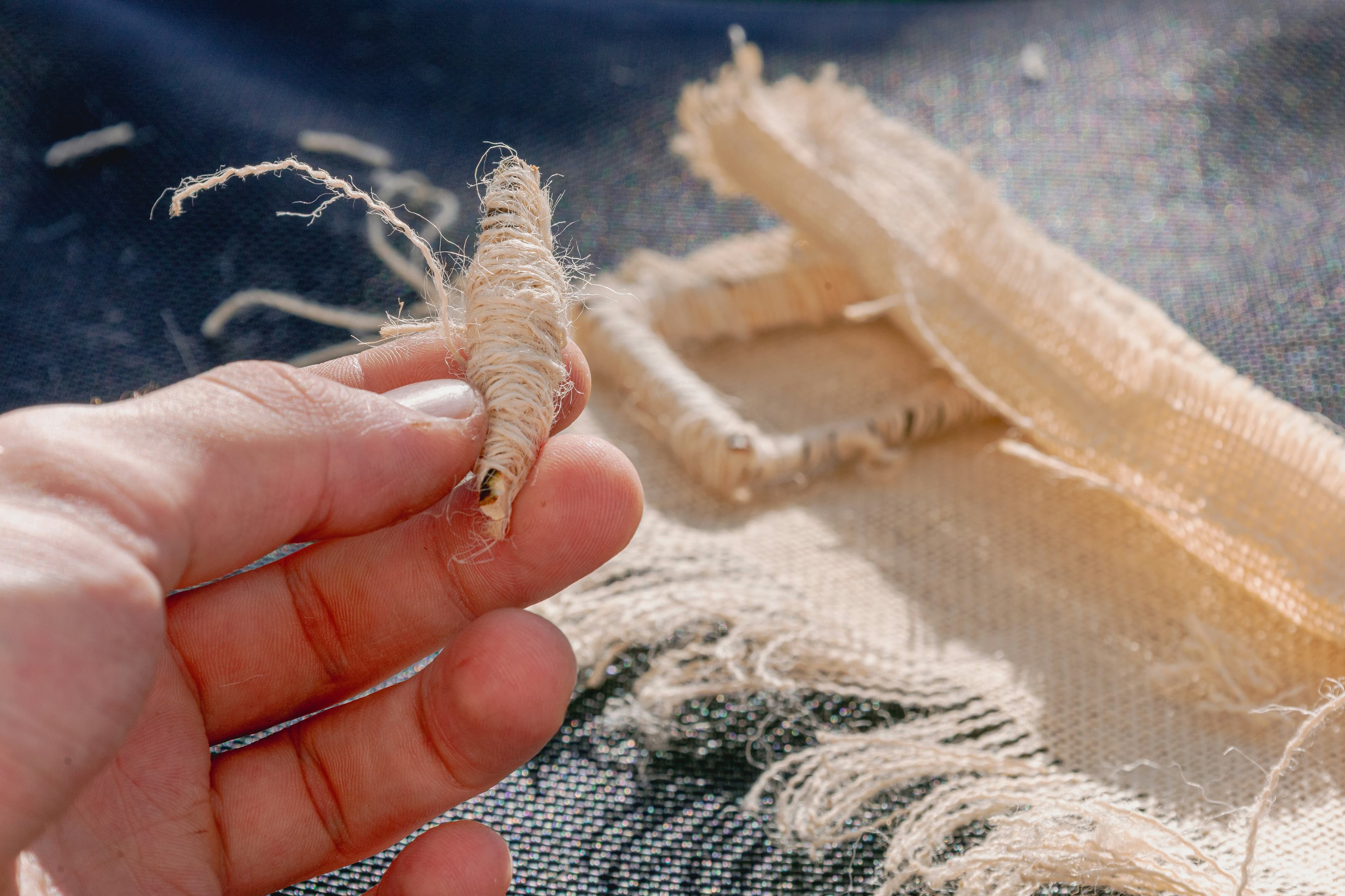Hands carefully working with natural textile fibers